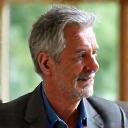 Smiling man in his mid-50s, David, enjoying a healthy meal or reflecting thoughtfully, looking calm and well.
