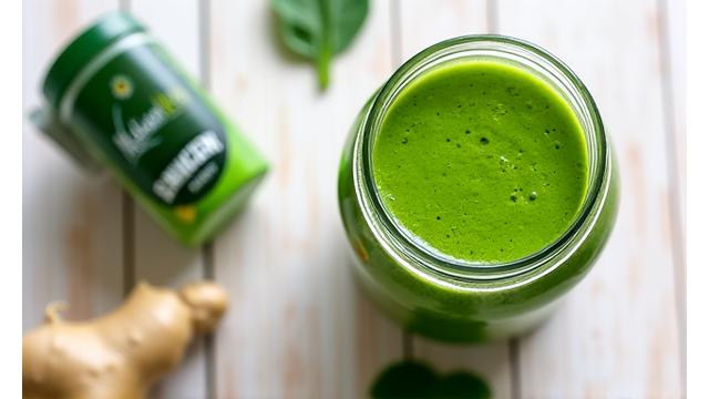 A vibrant green smoothie next to probiotic capsules, representing gut health and digestion.